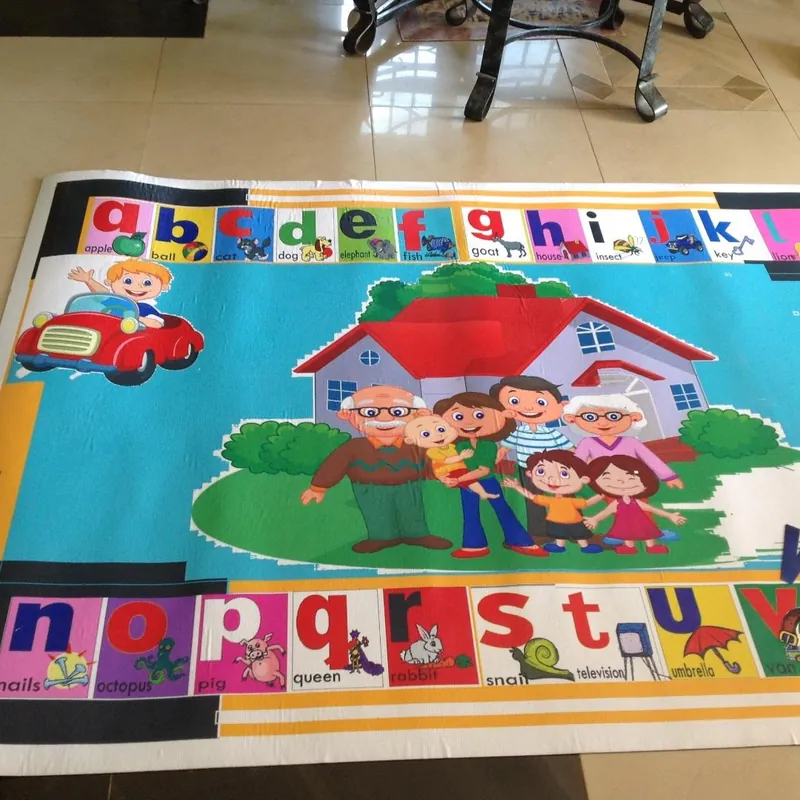 Classroom carpet with an alphabet border and a family in front of a house