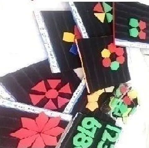 Black pattern boards with red, green and yellow shape pieces arranged into flower patterns